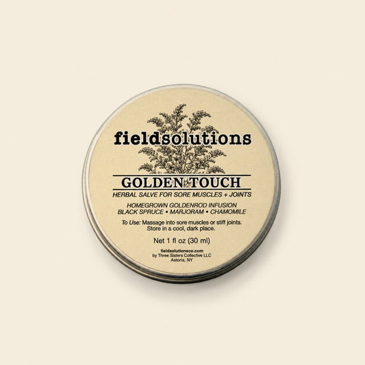 Golden Touch goldenrod massage salve in a round tin on a cream background